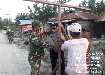 Personel Kodim 0208/Asahan Bahumembahu Bersama Warga Bangun Portal Jalan Desa