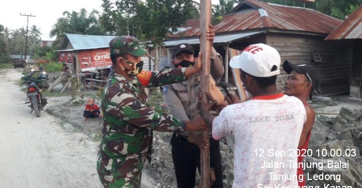 Personel Kodim 0208/Asahan Bahumembahu Bersama Warga Bangun Portal Jalan Desa