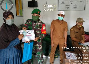 Personel Kodim 0208/Asahan Melalui Babinsa Mendampingi Aparat Desa Dalam Penyerahan Bantuan Sosial