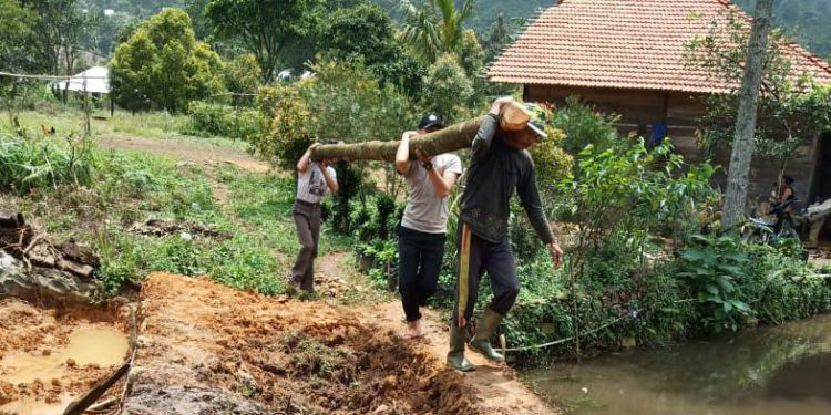 Polisi dan Warga Gotong Royong Membangun Kembali Jembatan Putus