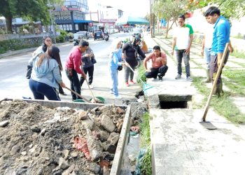 Cegah Banjir, Bhabinkamtibmas dan Warga Gotong Royong Bersihkan Parit di Jalan Rajamin Purba
