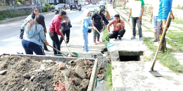 Cegah Banjir, Bhabinkamtibmas dan Warga Gotong Royong Bersihkan Parit di Jalan Rajamin Purba
