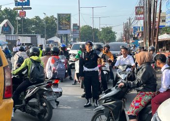 Urai Kepadatan Pagi Hari, Brimob Polda Sumut Kawal Kelancaran Lalu Lintas di Simpang Pajak Tuasan